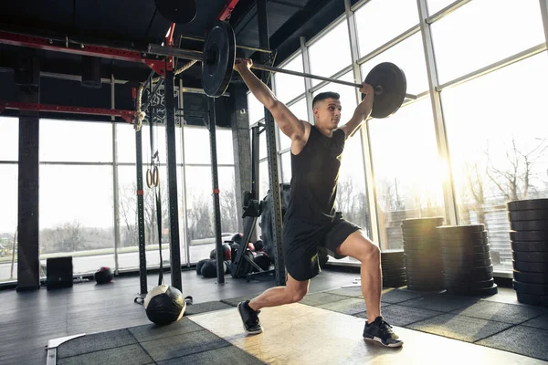 El atleta masculino entrena duro en el gimnasio. Fitness y concepto de vida saludable . — Foto de Stock