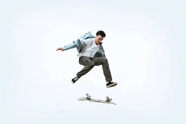 Caucasico giovane skateboarder equitazione isolato su uno sfondo bianco — Foto Stock