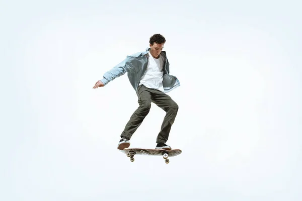 Caucasico giovane skateboarder equitazione isolato su uno sfondo bianco — Foto Stock