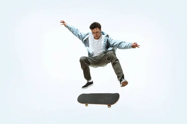 Юный кавказский скейтбордист на белом фоне — стоковое фото