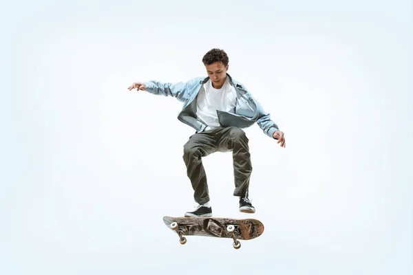 Caucasico giovane skateboarder equitazione isolato su uno sfondo bianco — Foto Stock