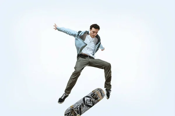 Caucásico joven skateboarder montar aislado sobre un fondo blanco —  Fotos de Stock