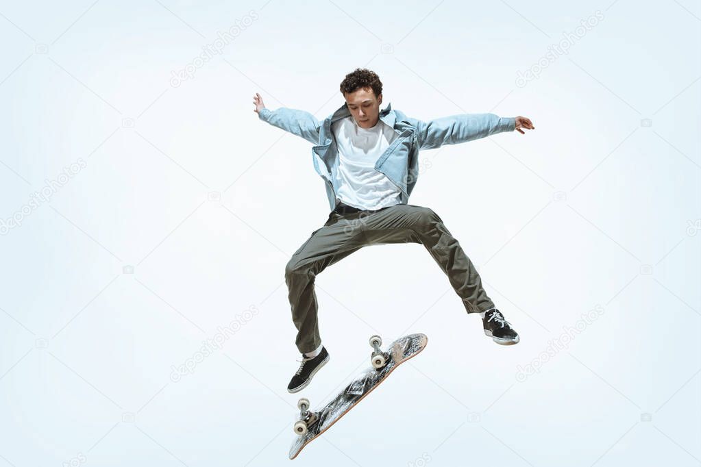 Caucasian young skateboarder riding isolated on a white background