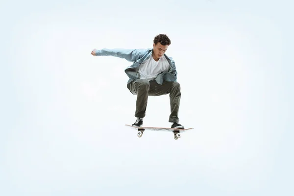 Caucásico joven skateboarder montar aislado sobre un fondo blanco —  Fotos de Stock