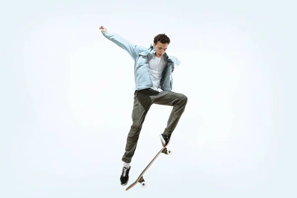 Caucasian young skateboarder riding isolated on a white background — 스톡 사진