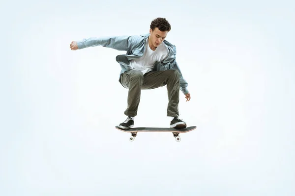 Kaukasische jonge skateboarder rijden geïsoleerd op een witte achtergrond — Stockfoto
