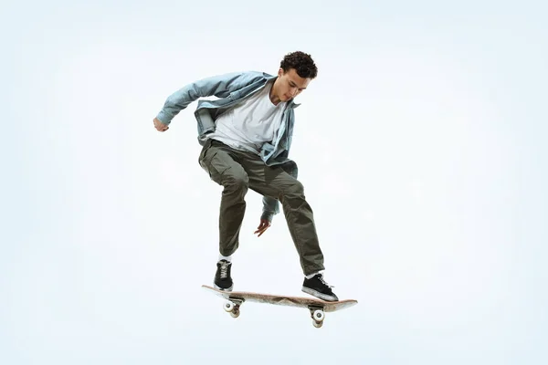 Kaukasischer junger Skateboarder reitet isoliert auf weißem Hintergrund — Stockfoto