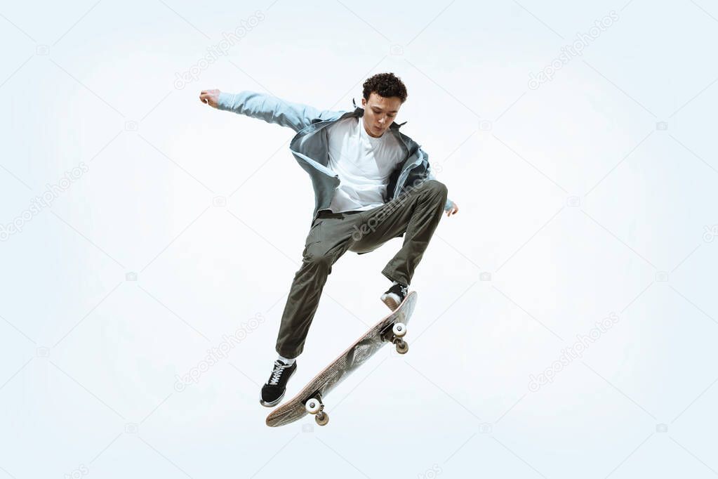 Caucasian young skateboarder riding isolated on a white background