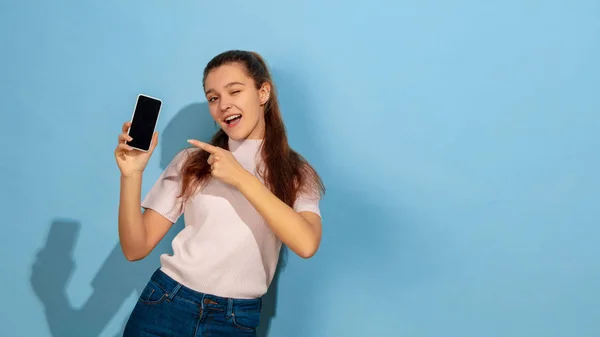 Caucasian teen girl portrait isolated on blue studio background — Stock Photo, Image