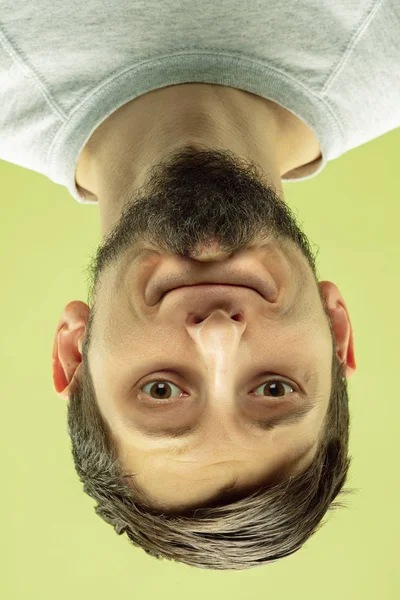 Retrato invertido del joven caucásico sobre fondo amarillo del estudio —  Fotos de Stock