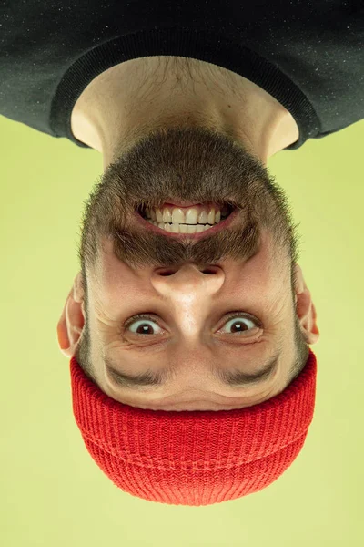 Retrato invertido de jovem caucasiano sobre fundo estúdio amarelo — Fotografia de Stock