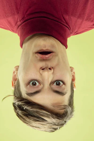 Inverted portrait of caucasian young man on yellow studio background — Stock Photo, Image