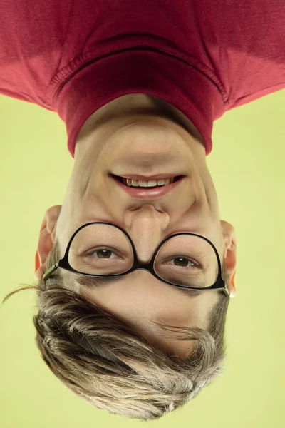 Inverted portrait of caucasian young man on yellow studio background — Stock Photo, Image