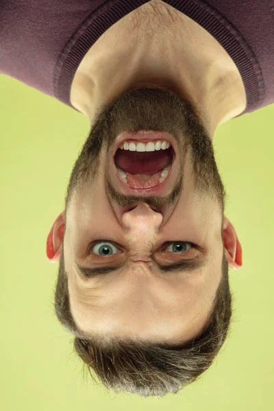 Retrato invertido del joven caucásico sobre fondo amarillo del estudio —  Fotos de Stock