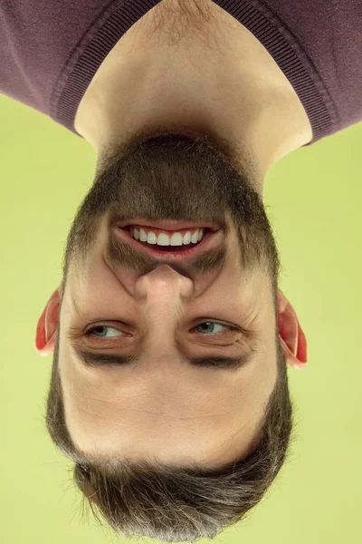 Retrato invertido de jovem caucasiano sobre fundo estúdio amarelo — Fotografia de Stock