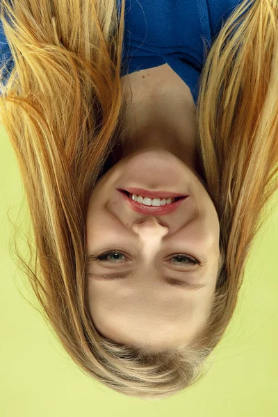 Inverted portrait of caucasian young woman on yellow studio background — Stock Photo, Image