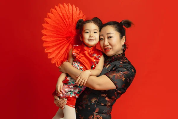 Feliz Año Nuevo Chino. Madre asiática e hija retrato aislado sobre fondo rojo — Foto de Stock
