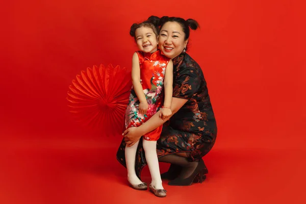 Gott nytt år för Kina. Asiatisk mor och dotter porträtt isolerad på röd bakgrund — Stockfoto