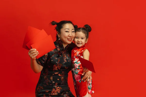 Gott nytt år för Kina. Asiatisk mor och dotter porträtt isolerad på röd bakgrund — Stockfoto