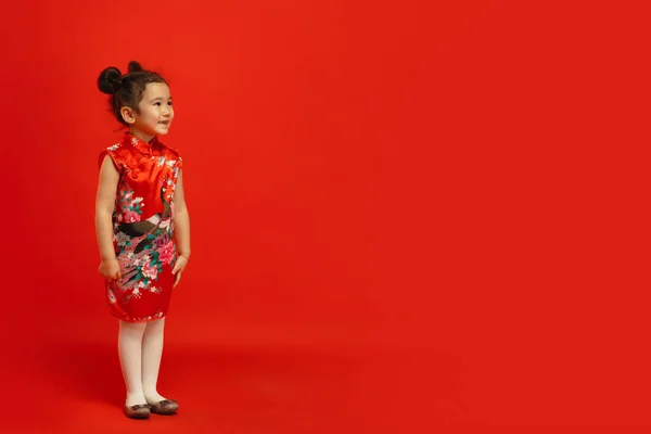 Feliz Año Nuevo Chino. Asiática niña retrato aislado en rojo fondo — Foto de Stock