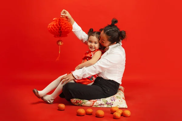 Feliz Año Nuevo Chino. Madre asiática e hija retrato aislado sobre fondo rojo — Foto de Stock