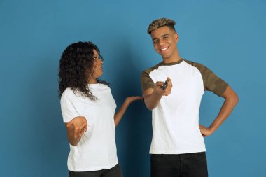 Mavi arka planda genç, duygusal, Afro-Amerikan erkek ve kadın