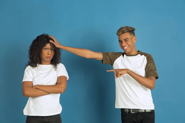 Mladý emocionální afroameričan muž a žena na modrém pozadí — Stock fotografie
