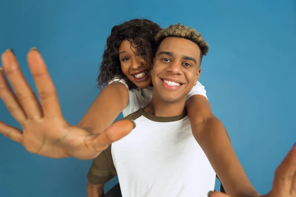 Mladý emocionální afroameričan muž a žena na modrém pozadí — Stock fotografie