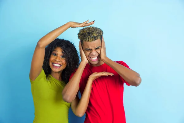 Jeune homme et femme afro-américain émotionnel sur fond bleu — Photo