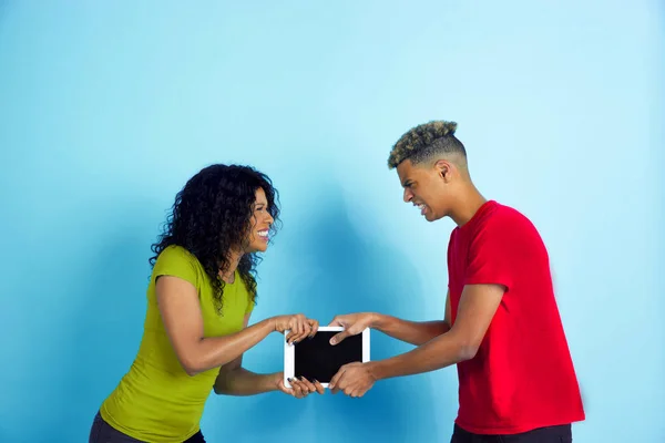 Jeune homme et femme afro-américain émotionnel sur fond bleu — Photo