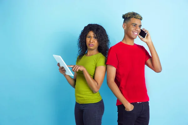 Joven afro-americano emocional hombre y mujer sobre fondo azul — Foto de Stock