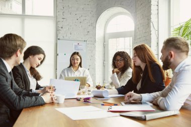 Bir grup genç iş adamı toplantı yapıyor, yaratıcı bir ofis.