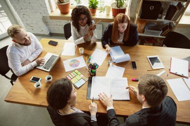 Bir grup genç iş adamı toplantı yapıyor, yaratıcı bir ofis.