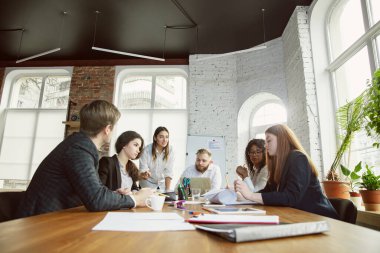 Bir grup genç iş adamı toplantı yapıyor, yaratıcı bir ofis.