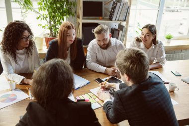 Bir grup genç iş adamı toplantı yapıyor, yaratıcı bir ofis.