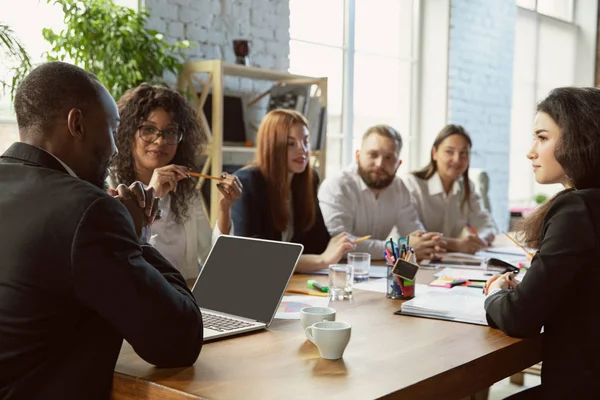 Bir grup genç iş adamı toplantı yapıyor, yaratıcı bir ofis.