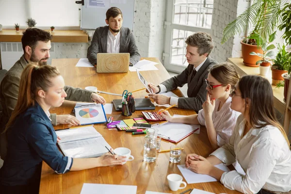 Bir grup genç iş adamı toplantı yapıyor, yaratıcı bir ofis.