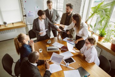 Bir grup genç iş adamı toplantı yapıyor, yaratıcı bir ofis.