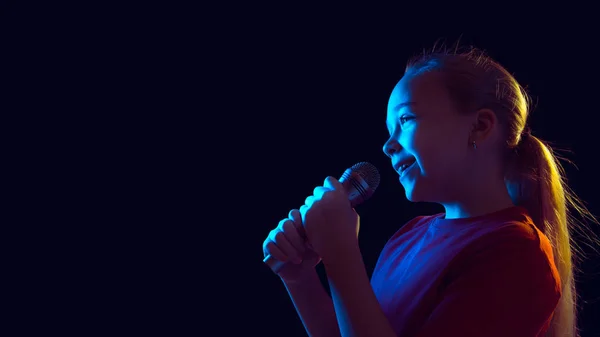 Kaukasische Mädchen Porträt isoliert auf dunklem Studiohintergrund in Neonlicht — Stockfoto