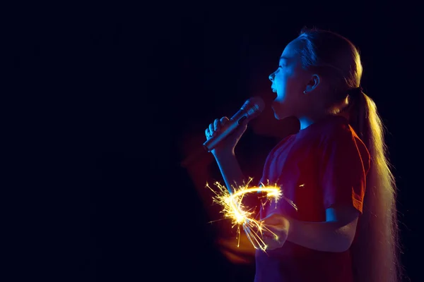 Kaukasische Mädchen Porträt isoliert auf dunklem Studiohintergrund in Neonlicht — Stockfoto