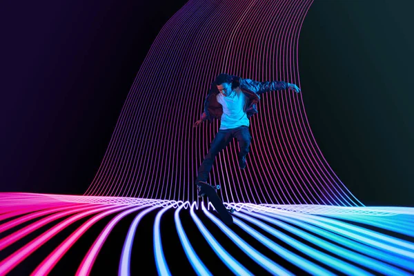 Caucasico giovane skateboarder equitazione su scuro neon illuminato linea di sfondo — Foto Stock