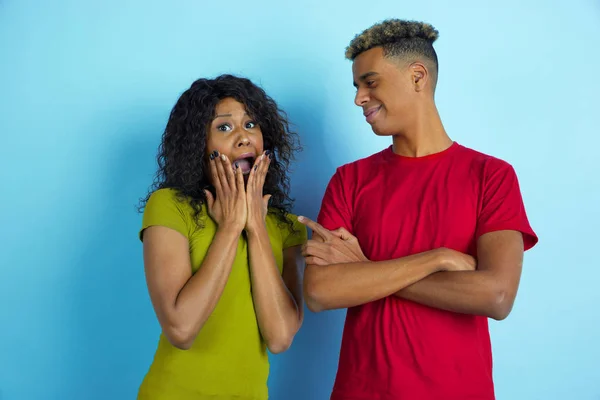 Jeune homme et femme afro-américain émotionnel sur fond bleu — Photo