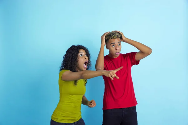 Young emotional african-american man and woman on blue background — 스톡 사진