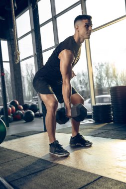 Erkek sporcu spor salonunda sıkı antrenman yapıyor. Fitness ve sağlıklı yaşam konsepti.