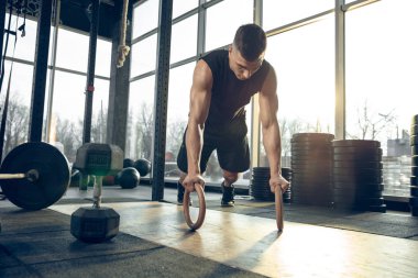 Erkek sporcu spor salonunda sıkı antrenman yapıyor. Fitness ve sağlıklı yaşam konsepti.