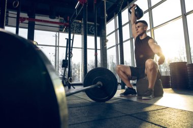 Erkek sporcu spor salonunda sıkı antrenman yapıyor. Fitness ve sağlıklı yaşam konsepti.