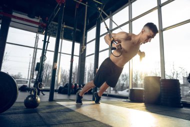 Erkek sporcu spor salonunda sıkı antrenman yapıyor. Fitness ve sağlıklı yaşam konsepti.