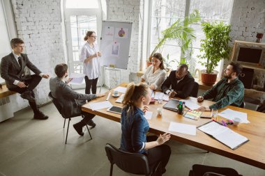 Bir grup genç iş adamı toplantı yapıyor, yaratıcı bir ofis.