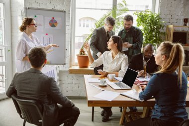 Bir grup genç iş adamı toplantı yapıyor, yaratıcı bir ofis.