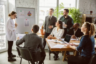 Bir grup genç iş adamı toplantı yapıyor, yaratıcı bir ofis.